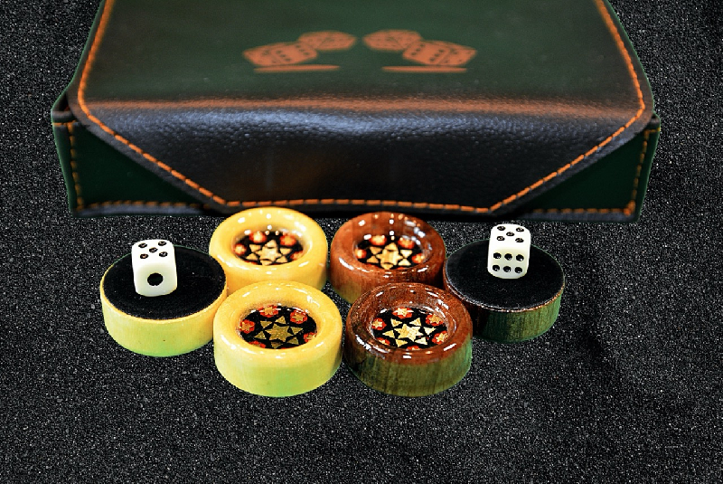 Backgammonstein-Set und zwei Wurfel mit Kunstledertasche im Hintergrund
